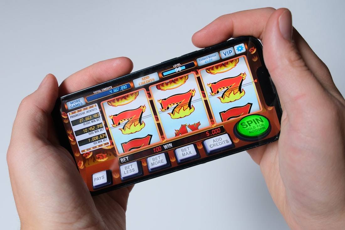 Tangan memegang ponsel saat bermain game kasino mobile